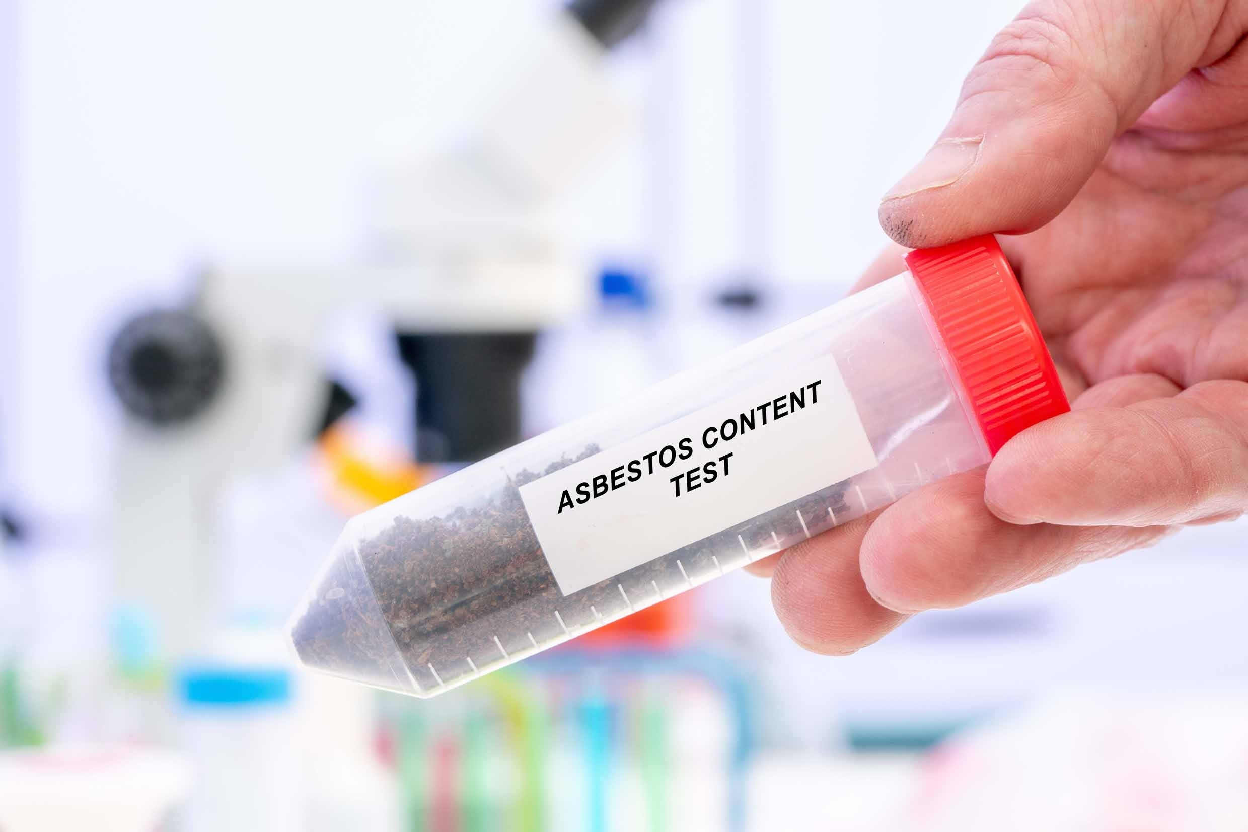 A hand showing asbestos content in a container for asbestos reinspection survey.